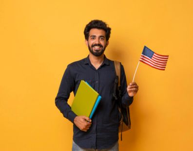 An Indian student holding a USA flag